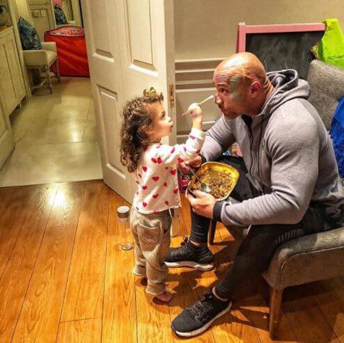 Jasmine Johnson painting her father, Dwayne Johnson's face.